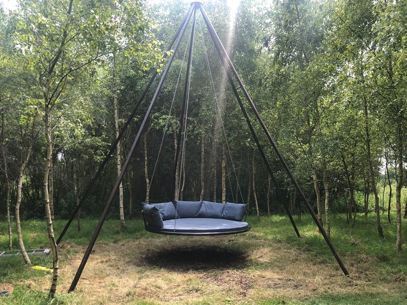A bespoke garden swing is fitted with a custom made outdoor round seat cushion and fibre filled back cushions
